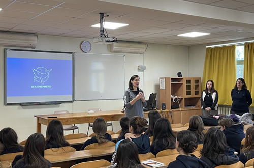 Members of the Sea Shepherd Conservation Society speak to Athens College Junior High School students